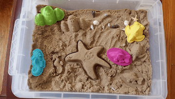 Sand sensory bin filled with sand toys for playing in the sand with 